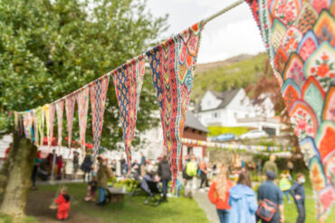 Mennesker samlet utendørs på gårdsplass i nabolag.